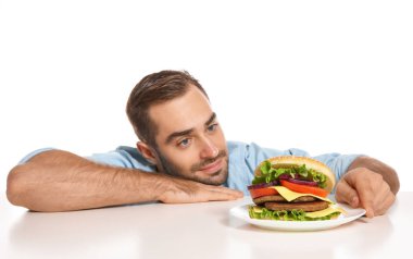 Beyaz zemin üzerine lezzetli hamburger ile genç adam