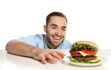 Genç aç adam beyaz zemin üzerine lezzetli hamburger ile