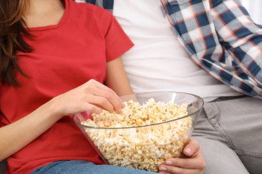 Genç çift kanepe evde patlamış mısır ile TV izleme