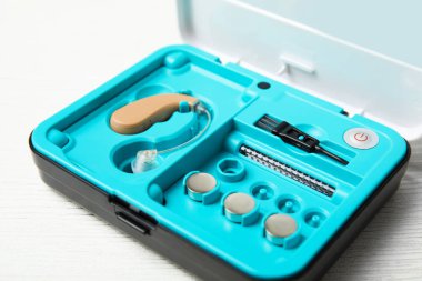 Beyaz ahşap zemin üzerinde işitme cihazı ile durum