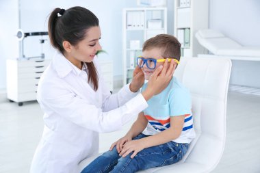 Çocuk Kliniği oftalmik ekipmanları ile inceleyerek küçük çocuk doktor