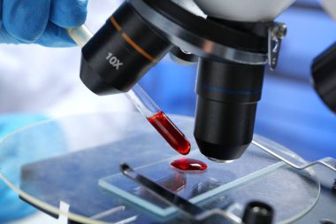 Kan testi mikroskop, closeup kullanarak çalışan laboratuvar işçi. Araştırma ve analiz