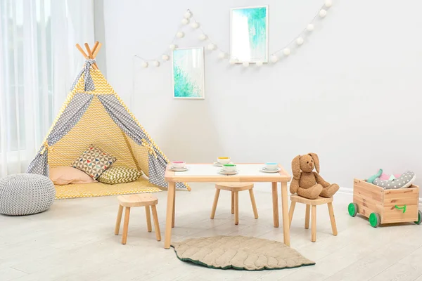 舒适的儿童房间内有桌子 玩帐篷和玩具 — 图库照片