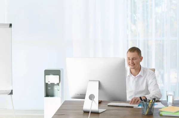 Office employee at desk near water cooler