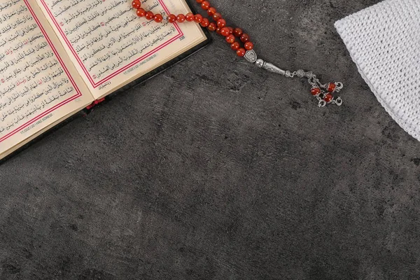 Müslüman tespih, Kur'an-ı Kerim ve gri arka plan üzerinde metin için yer düz yatıyordu kompozisyonu