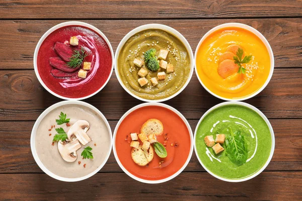 Çeşitli krem Çorbalar kase ahşap arka plan, üstten görünüm