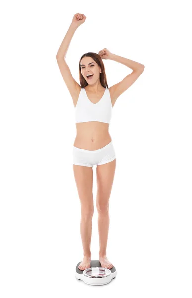 スリムな女性は 白い背景に 体重計の上に立って 体重減少 — ストック写真