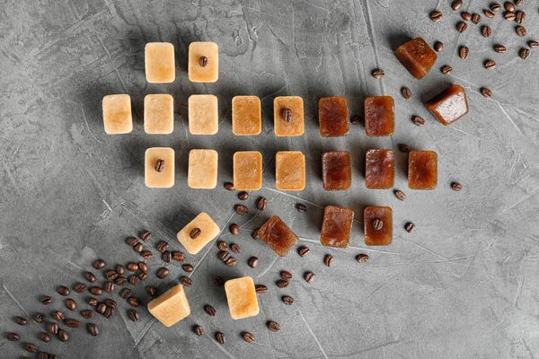 Gri arka plan üzerinde kahve buz küpleri ile düz yatıyordu kompozisyon