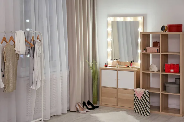 Dressing room interior with makeup mirror, wardrobe rack and shelving unit