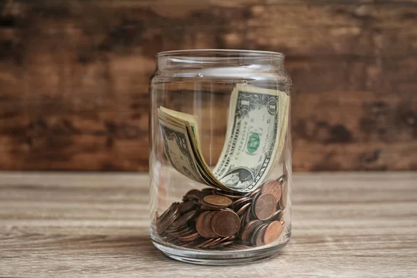 Donation jar with money on wooden table