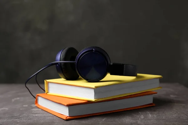 Modern headphones with hardcover books on table