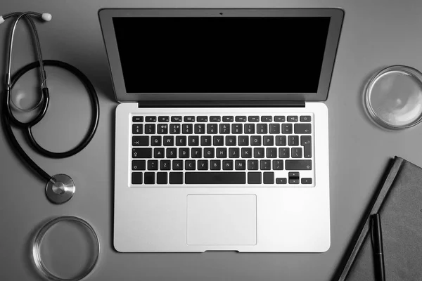 Modern laptop and medical students stuff on table, top view