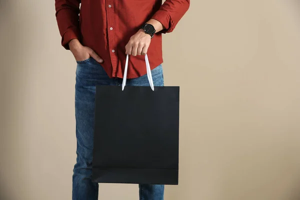 Joven Sosteniendo Bolsa Papel Sobre Fondo Color Primer Plano Burla —  Fotos de Stock