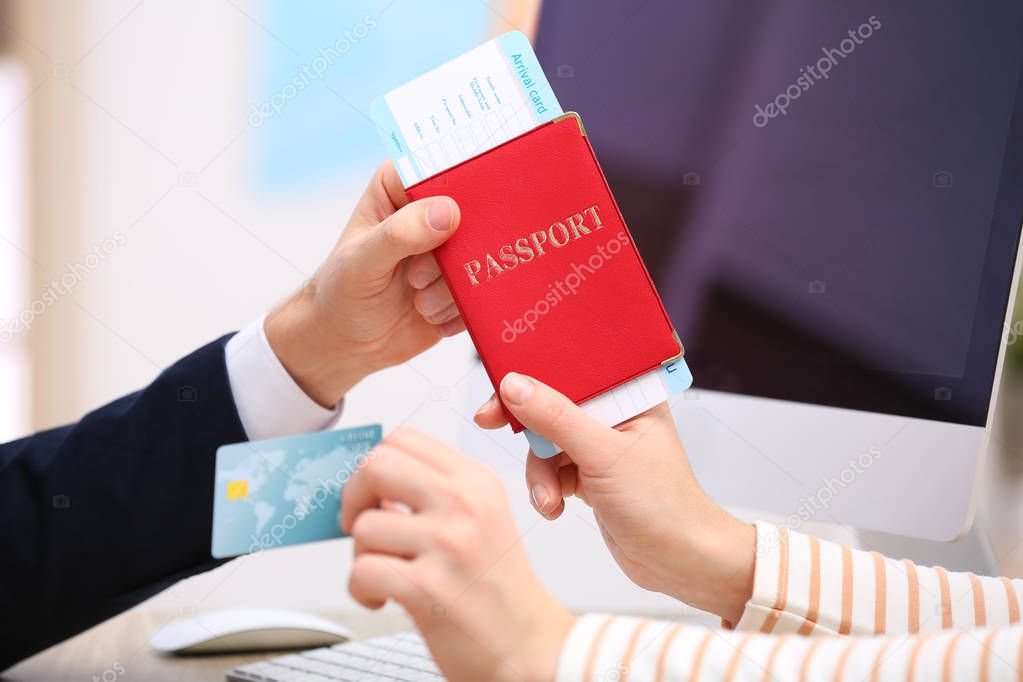 Male manager giving passport with ticket to client in travel agency, closeup