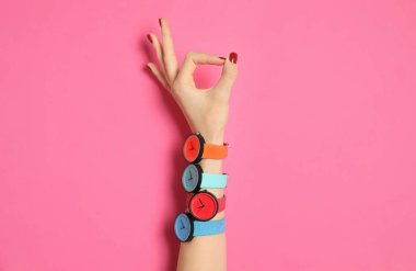 Renk arka plan, closeup üzerinde birçok parlak kol saatleri olan kadın. Moda aksesuar