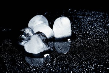 Siyah arka plan üzerinde eriyen buz küpleri. Metin için yer