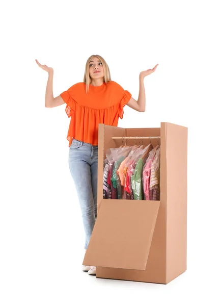 Young emotional woman near wardrobe box on white background