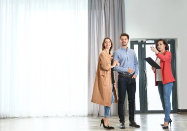 Emlakçı gösteren genç bir çift yeni daireye. Metin için yer