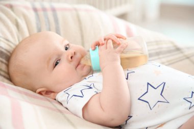 Güzel bebek şişe yatakta evde içme
