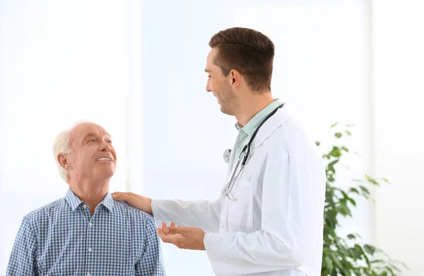 医生和老年病人在医院握手 文本的空间 — 图库照片