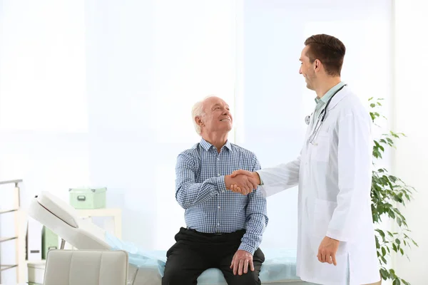 医師や高齢者の患者が病院で握手します テキストのためのスペース — ストック写真