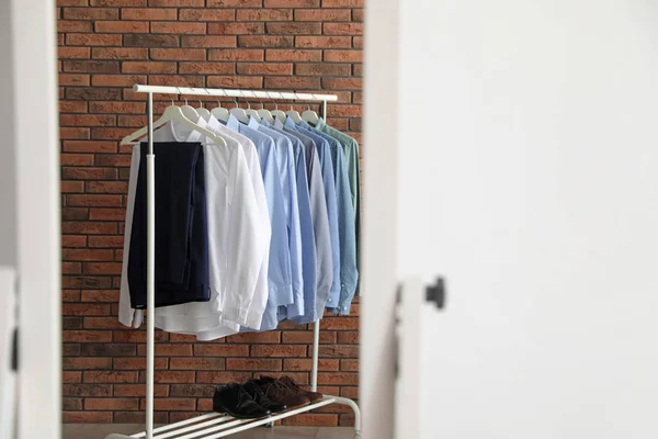 Reflexion Von Kleiderständern Mit Männerkleidung Der Nähe Von Ziegelwänden Spiegel — Stockfoto