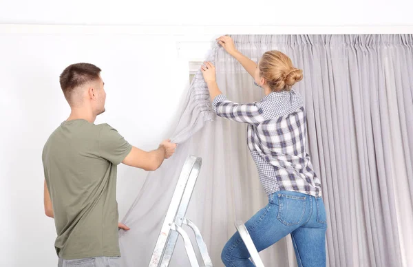 Young Couple Hanging Window Curtain Indoors Interior Decor Element — Stock Photo, Image