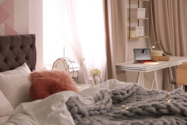 Büyük rahat yatak ve çalışma alanı ile şık daire içinde laptop. Oda iç