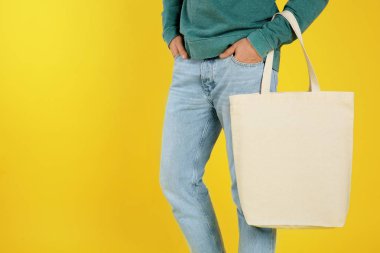 Tekstil çanta renk arka plan, closeup üzerinde tutan genç adam. Mockup tasarım için