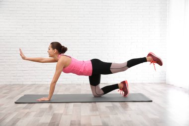 Beyaz arka plan üzerinde egzersiz yaparak dumbbells ile genç güzel kadın. Ev fitness