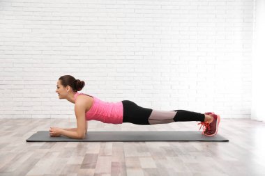 Beyaz arka plan üzerinde egzersiz yaparak dumbbells ile genç güzel kadın. Ev fitness