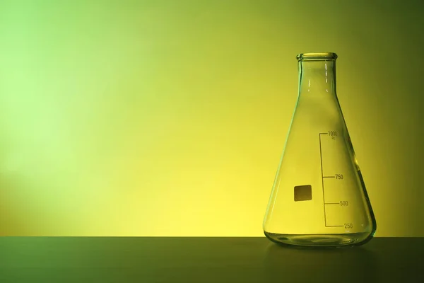 Renk Arka Plan Karşı Masada Boş Koni Şişesi Kimya Laboratuar — Stok fotoğraf