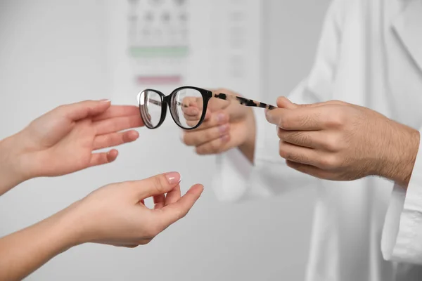 Αρσενικό Οφθαλμίατρο Βοηθώντας Γυναίκα Επιλέξετε Γυαλιά Στην Κλινική Κοντινό Πλάνο — Φωτογραφία Αρχείου