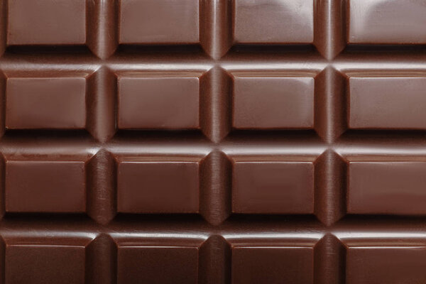 Tasty dark chocolate bar as background, top view