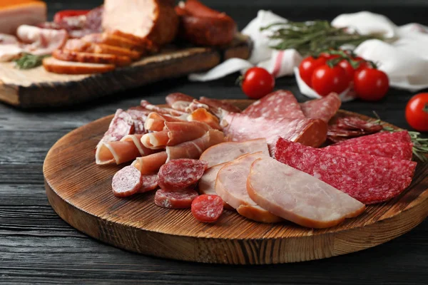 桌子上有不同切片肉制品的切割板 免版税图库照片