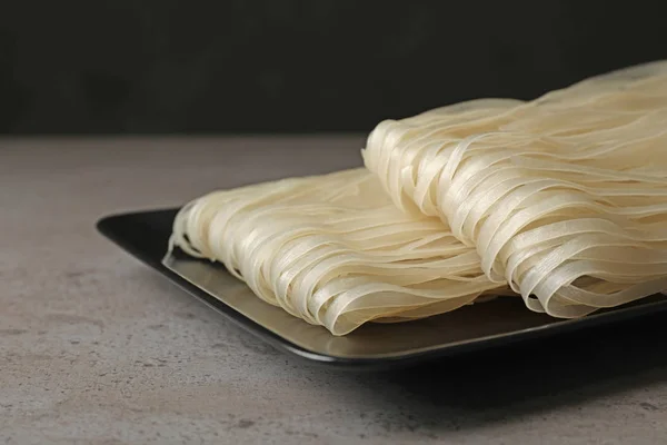 Plate Raw Rice Noodles Grey Table Closeup Delicious Pasta — Stock Photo, Image