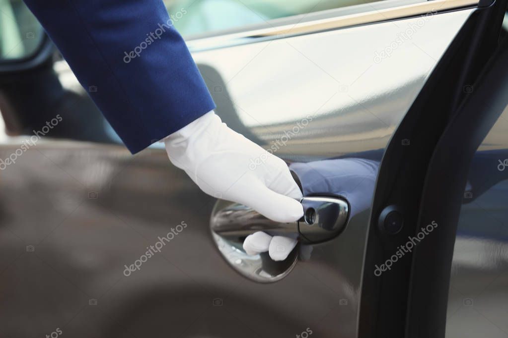 Closeup view of chauffeur opening car door