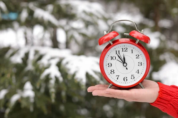 Mujer Sosteniendo Despertador Rojo Cerca Abeto Cubierto Nieve Aire Libre —  Fotos de Stock