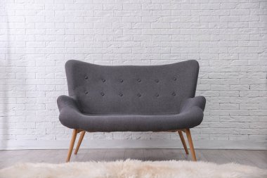 Basit salon iç tuğla duvarının yakınında rahat kanepe ile