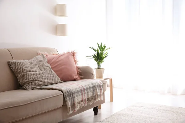 Simple living room interior with comfortable sofa near brick wall