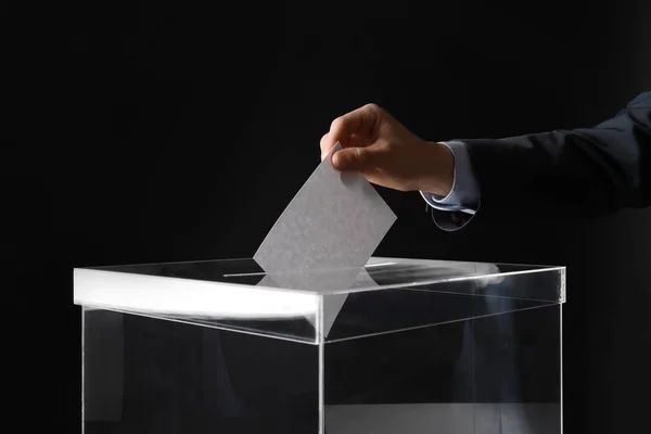 Mann Legt Seine Stimme Die Wahlurne Auf Schwarzem Hintergrund Nahaufnahme — Stockfoto