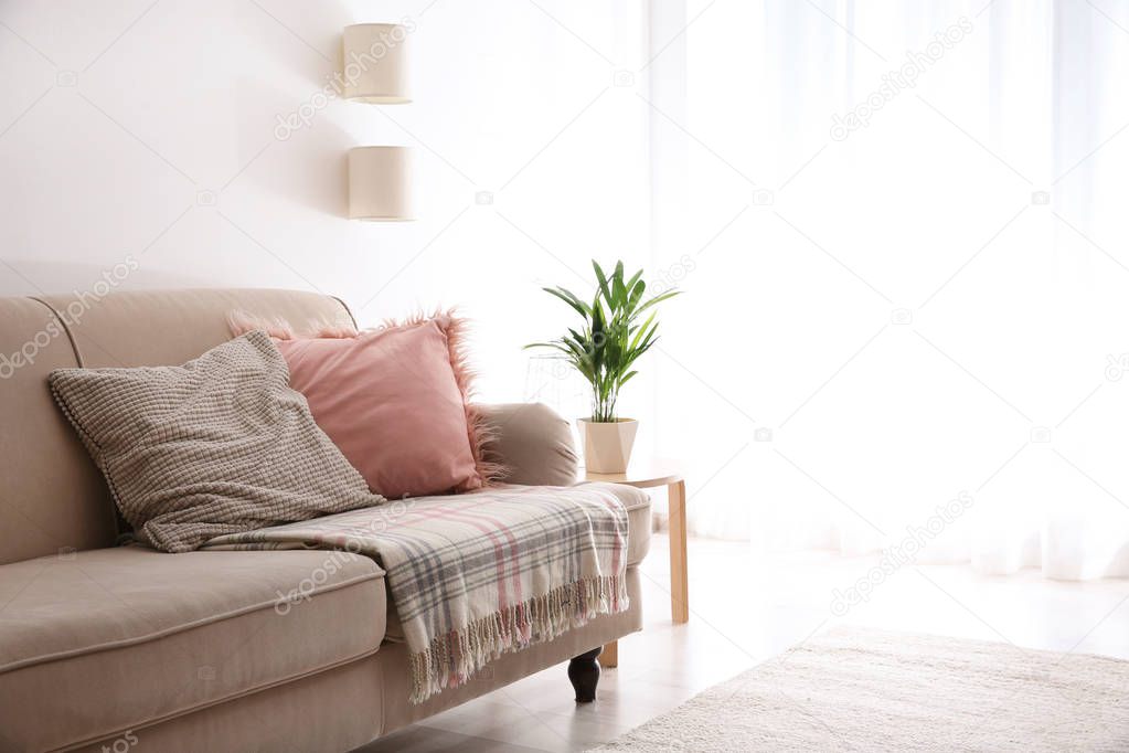 Simple living room interior with comfortable sofa near brick wall