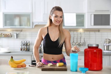 Genç kadın protein içeceği mutfak masasında hazırlanıyor