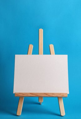 Ahşap şövale renk arka plan üzerinde boş tuval kurulu ile. Çocuk boyama