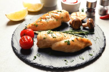 Kızarmış tavuk göğsü ve garnitür ile kayrak plaka masaya servis