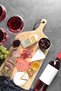 Şarap ve aperatifler gri arka plan üzerinde düz yatıyordu kompozisyonu