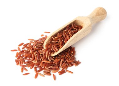 Kepçe ve beyaz arka plan üzerinde kahverengi pirinç pişmemiş