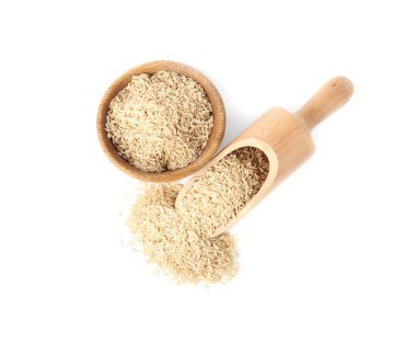 Kase ve kepçe pişmemiş kahverengi pirinç beyaz arka planda, üstten görünüm