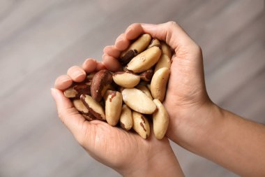 Brezilya fıstığı elinde tutan kadın arka plan, üstten görünüm bulanık