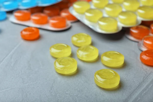 Color cough drops on grey background, closeup